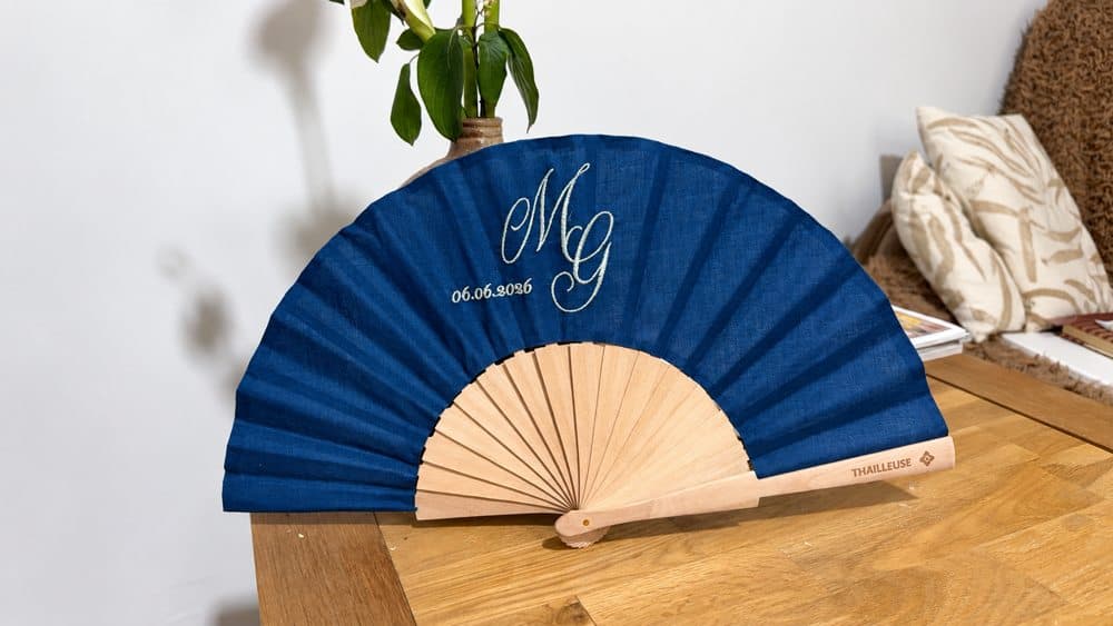 Éventail bleu brodé d’initiales et d’une date, avec monture en bois gravée