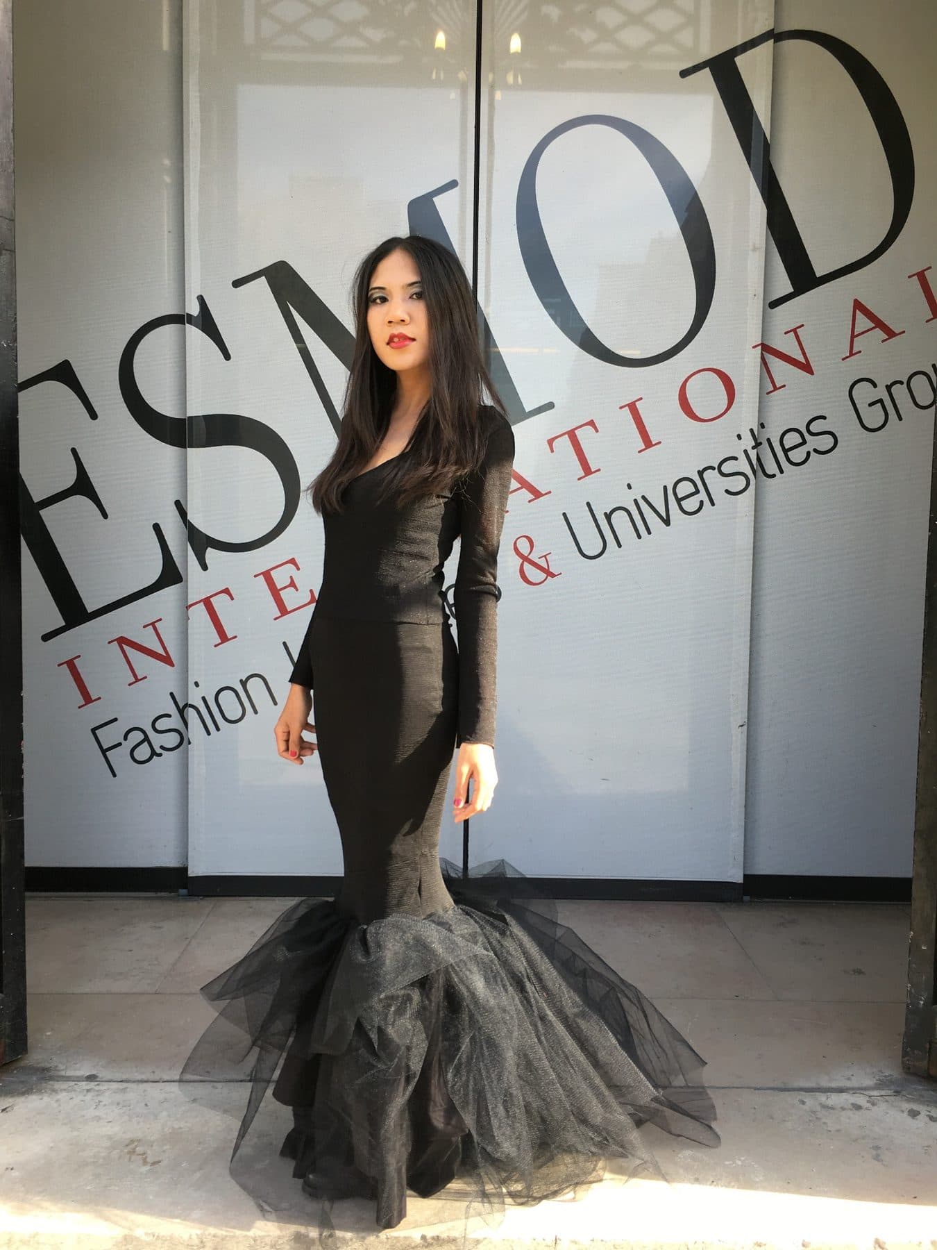 Julie Foucré devant ESMOD Paris, portant une robe noire aux volumes de tulle sculpturaux